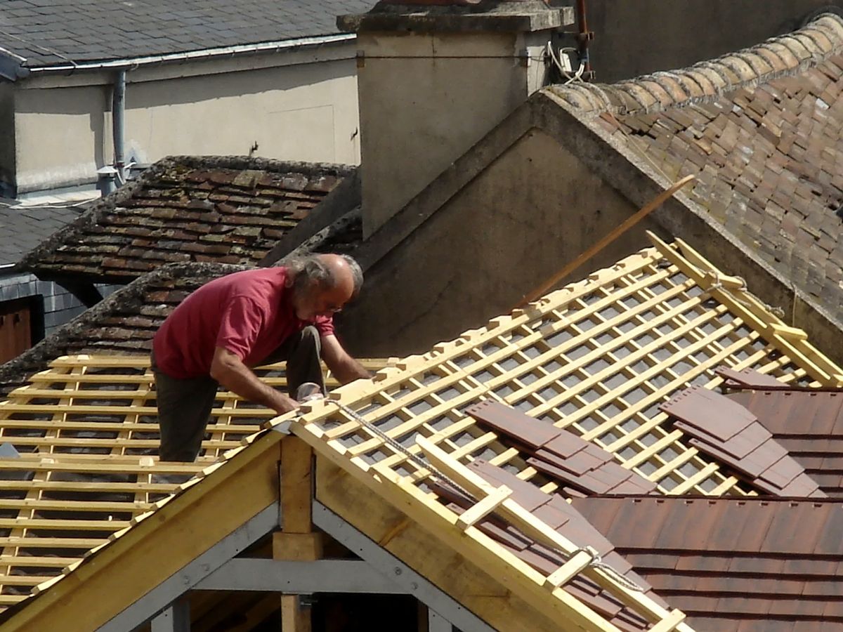 Couvreur posant des éléments de couverture sur un toit en pente