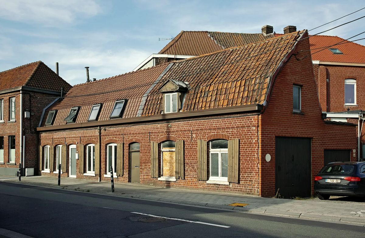 Maisons basses en brique rouge avec toiture en tuiles le long d'une rue d'Estaimpuis