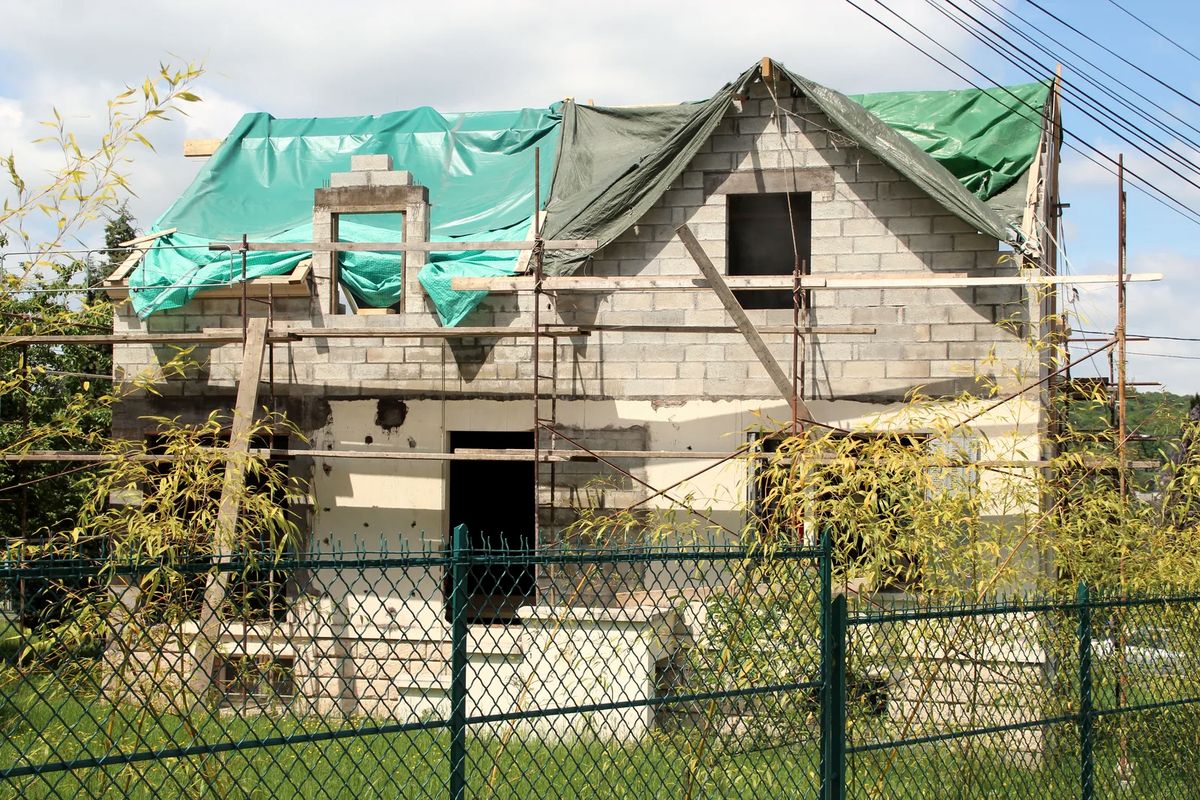 Maison de ville en cours de rehausse, avec étage ajouté en chantier à un carrefour