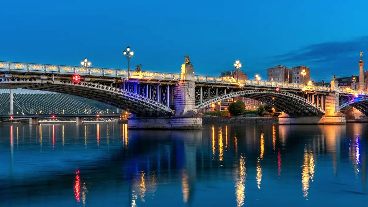 Pont de Fragnée illuminé à la tombée de la nuit au-dessus de la Meuse à Liège