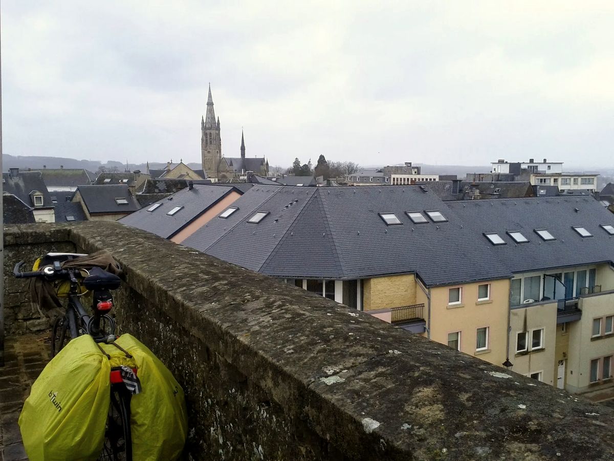 Toits en ardoise gris foncé d'Arlon avec le clocher de l'église en arrière-plan